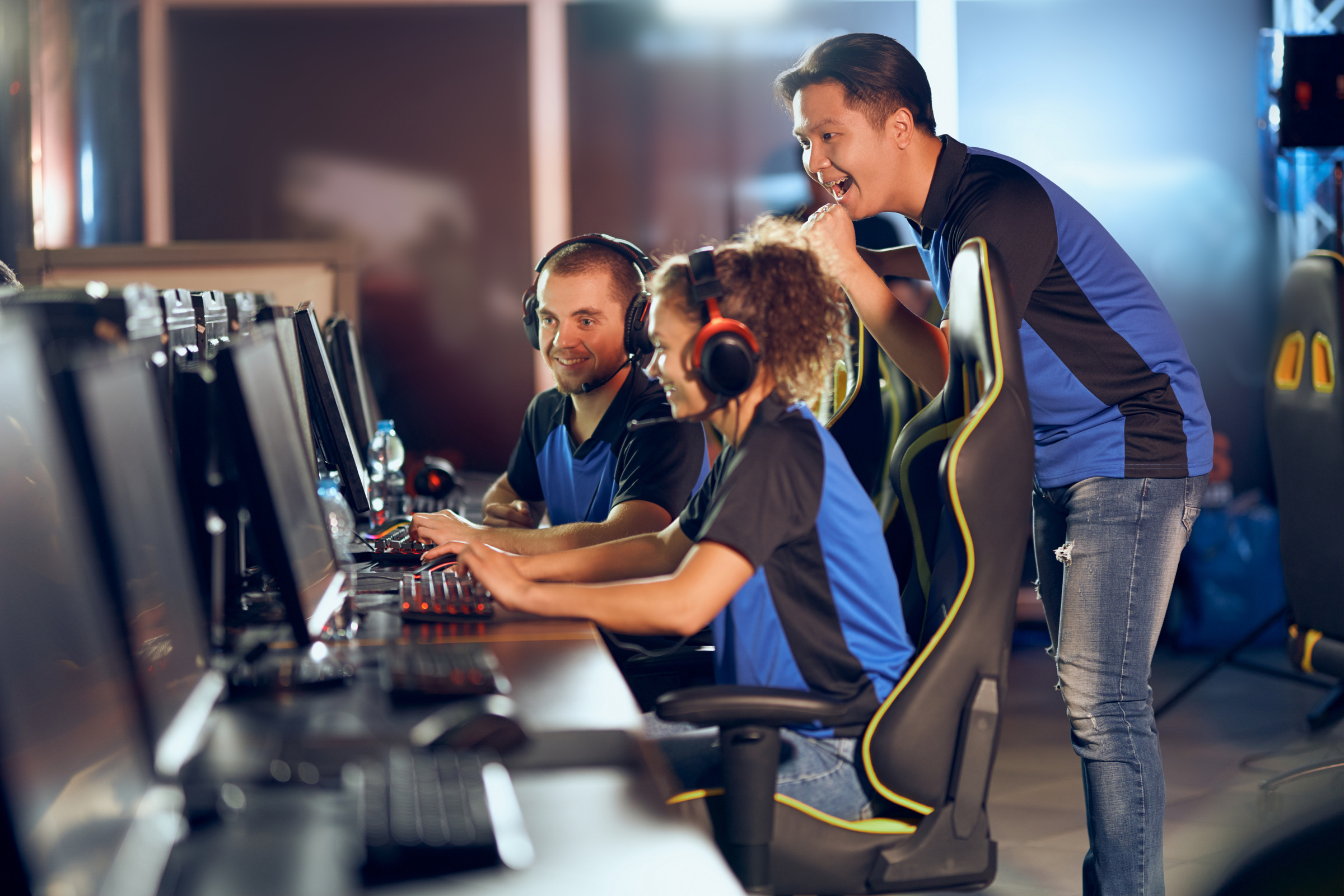 Celebrating success. Team of professional teenage cyber sport gamers participating in eSports tournament